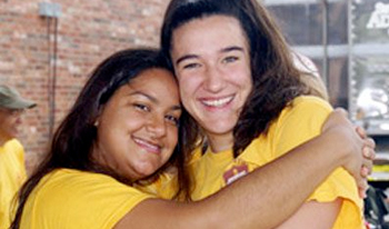 Two girls smile and hug for a photo