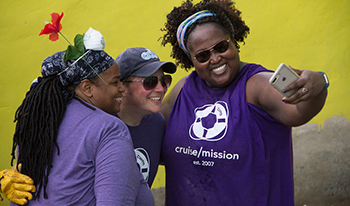 Three volunteers pose together for a phone photo